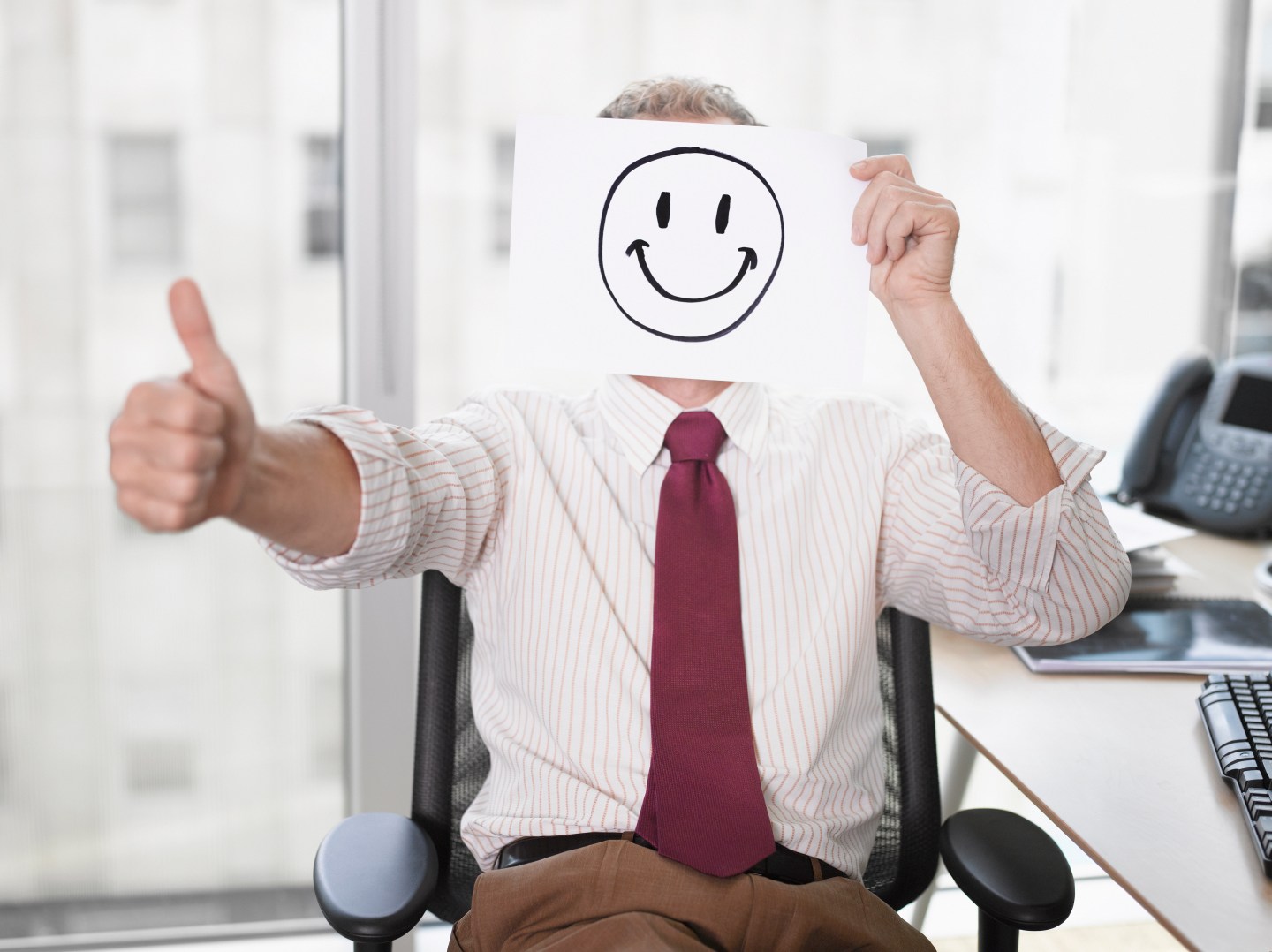 Businessman holding picture of happy face
