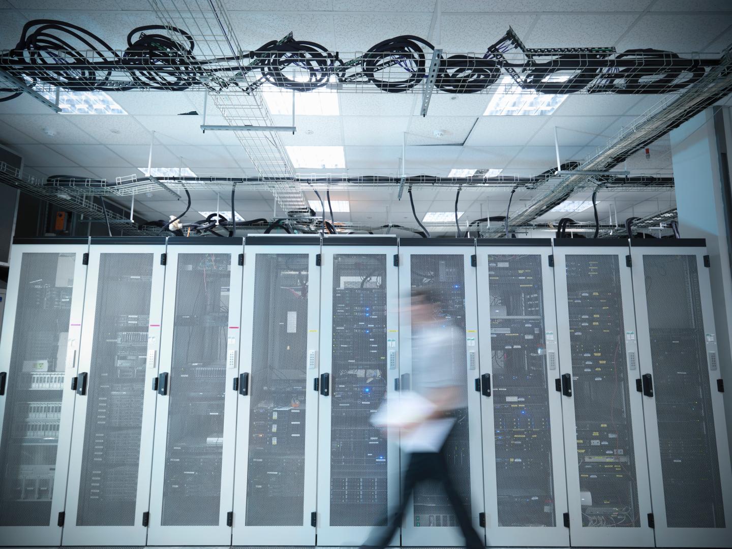 Man walking through computer server room, blurred motion