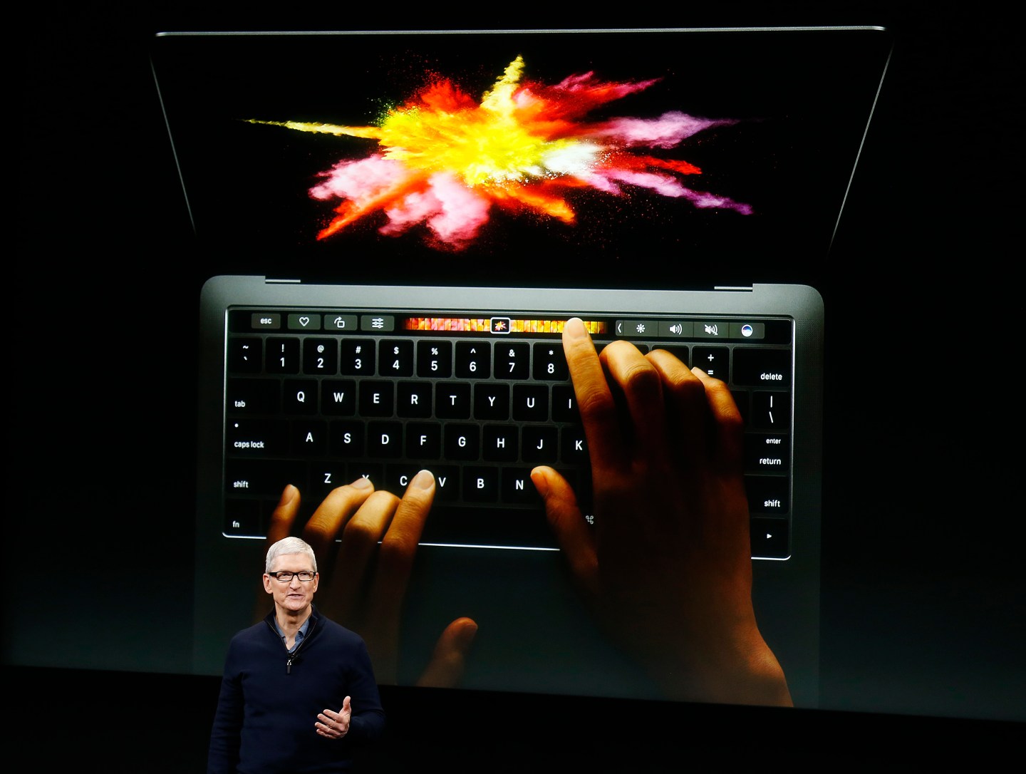Apple CEO Tim Cook speaks under a graphic of the new MacBook Pro during an Apple media event in Cupertino