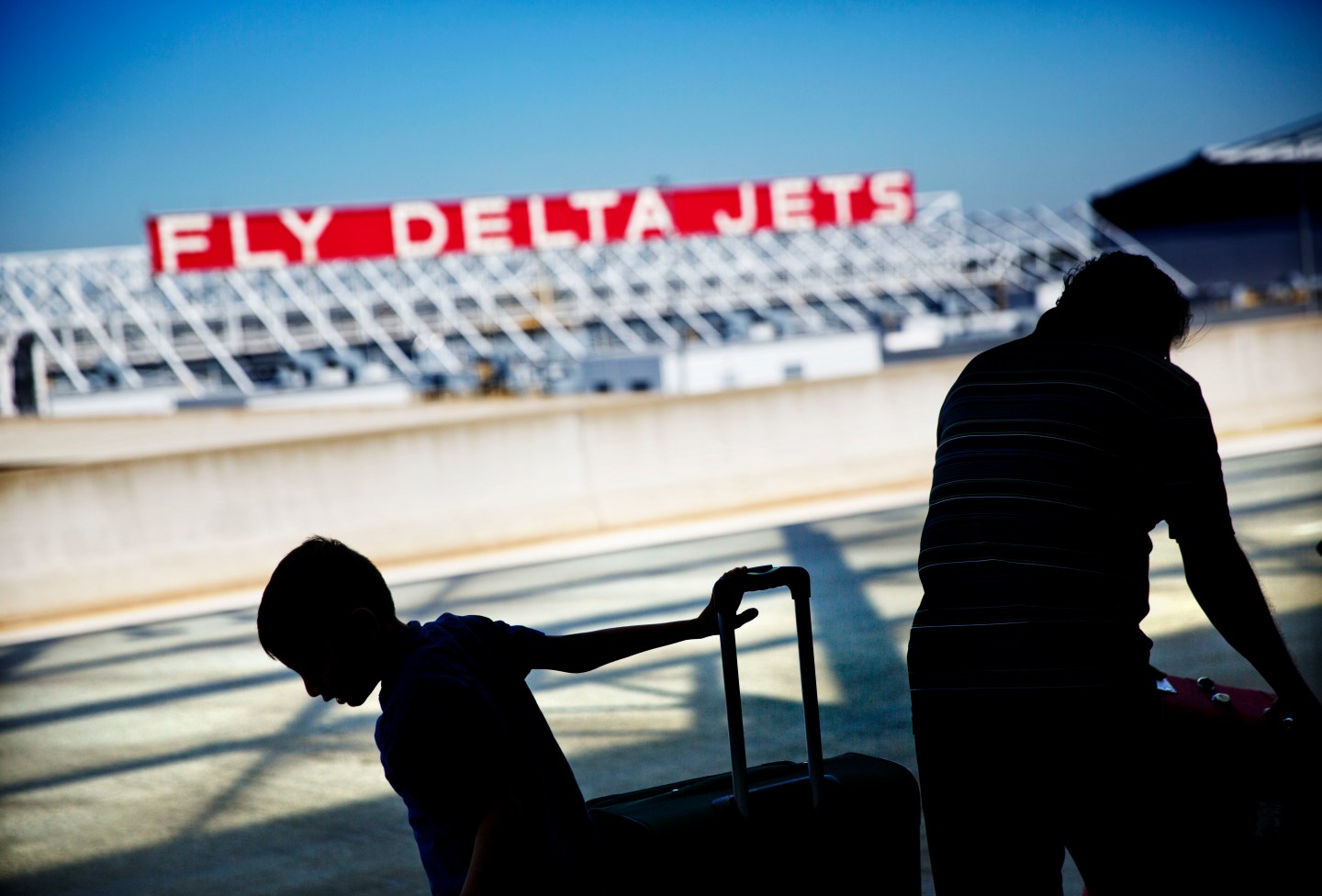 Passengers unload in front of a Delta Air Lines sign at Hartsfield-Jackson Atlanta International Airport, in Atlanta, Thursday, Oct. 13, 2016.