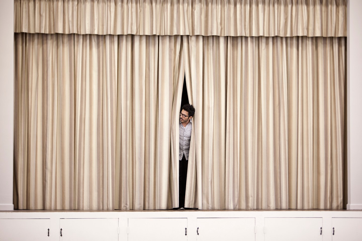 Hispanic man peering out from backstage