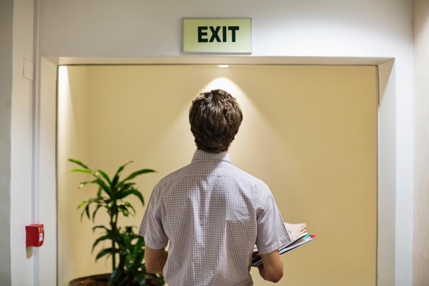 Businessman examining ëexití sign in office