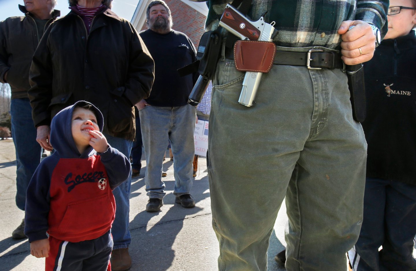 Samson Hiltz, 2, looks up to his father Jeremy Hiltz of Chelsea while the two attend a rally protest