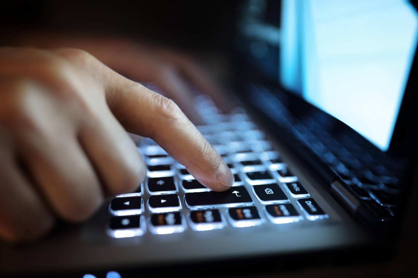 Hands typing on laptop computer