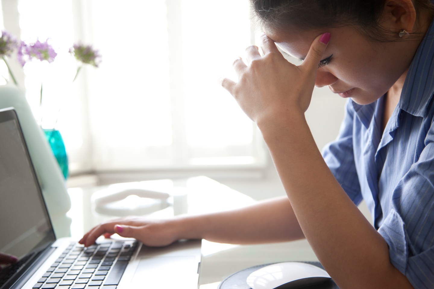 Businesswoman with Hands on Head Using Laptop