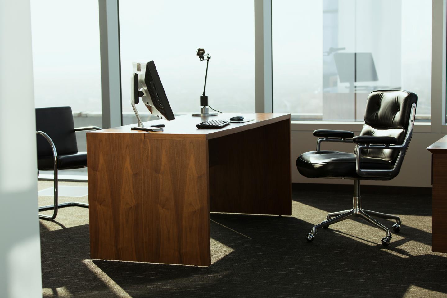 bright corner office space with desk and chairs