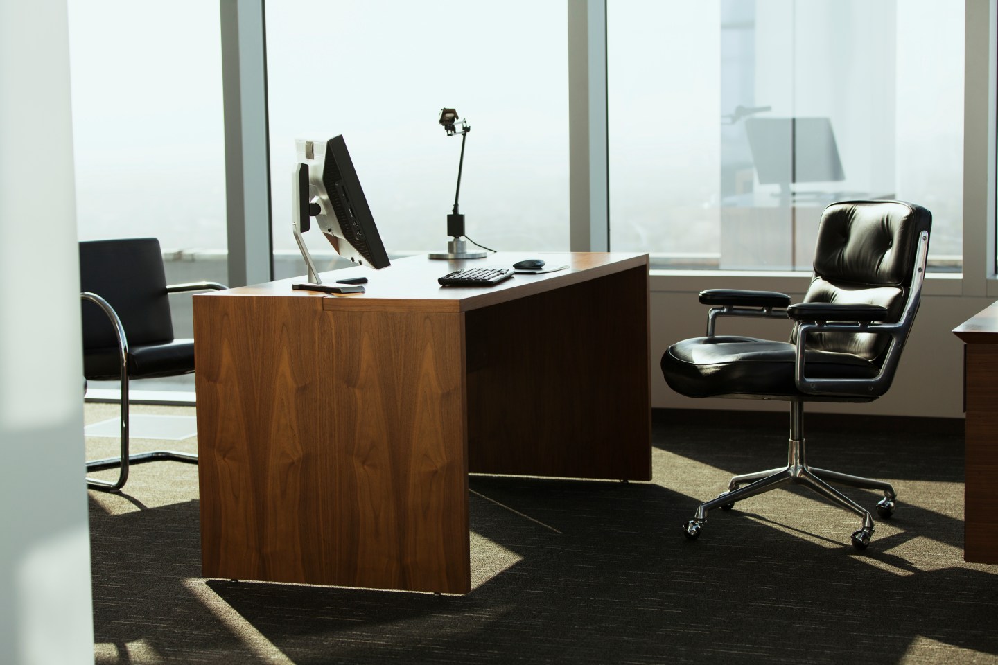 bright corner office space with desk and chairs