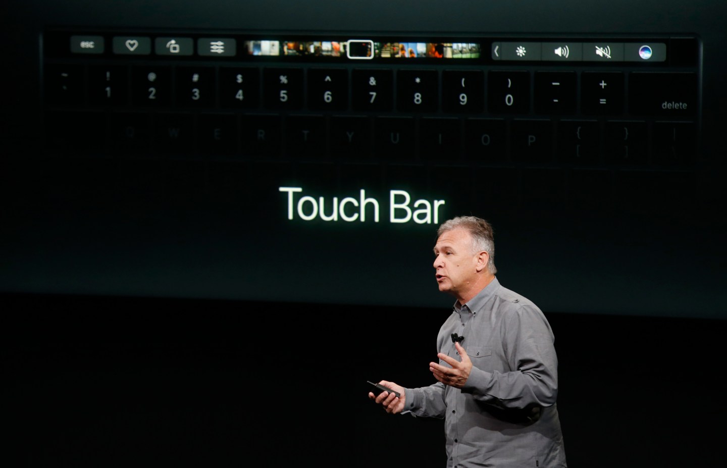 Phil Schiller, senior vice president of worldwide marketing at Apple, speaks under a graphic of a new MacBook Pro during an Apple media event in Cupertino