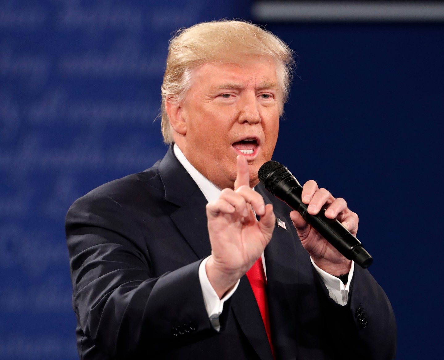 Republican U.S. presidential nominee Trump speaks as Democratic U.S. presidential nominee Clinton listens during their presidential town hall debate in St. Louis