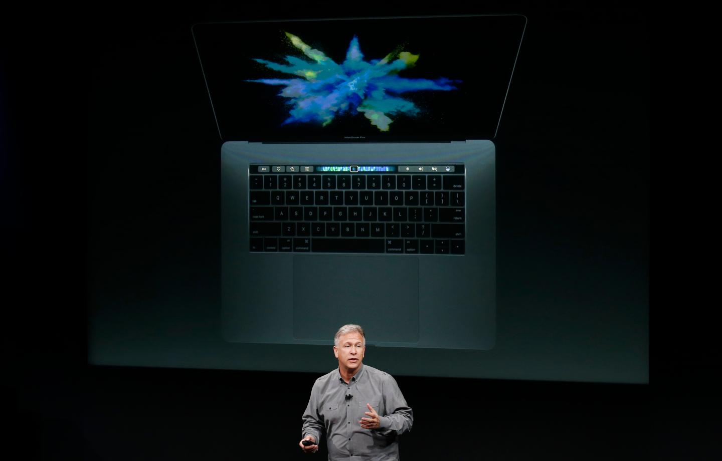 Phil Schiller, senior vice president of worldwide marketing at Apple, speaks under a graphic of a new MacBook Pro during an Apple media event in Cupertino
