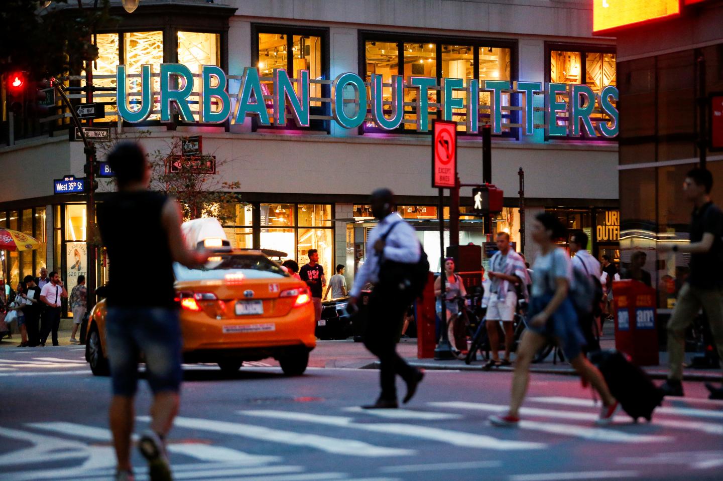 People crosses the street next to the Urban Outfitters store in Manhattan, New York, U.S., August 15, 2016.