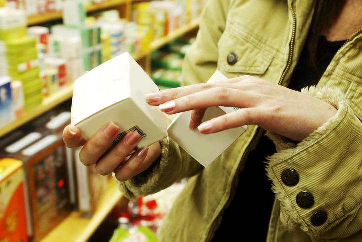 Chest view of a female shopper looking at a cosmetic box