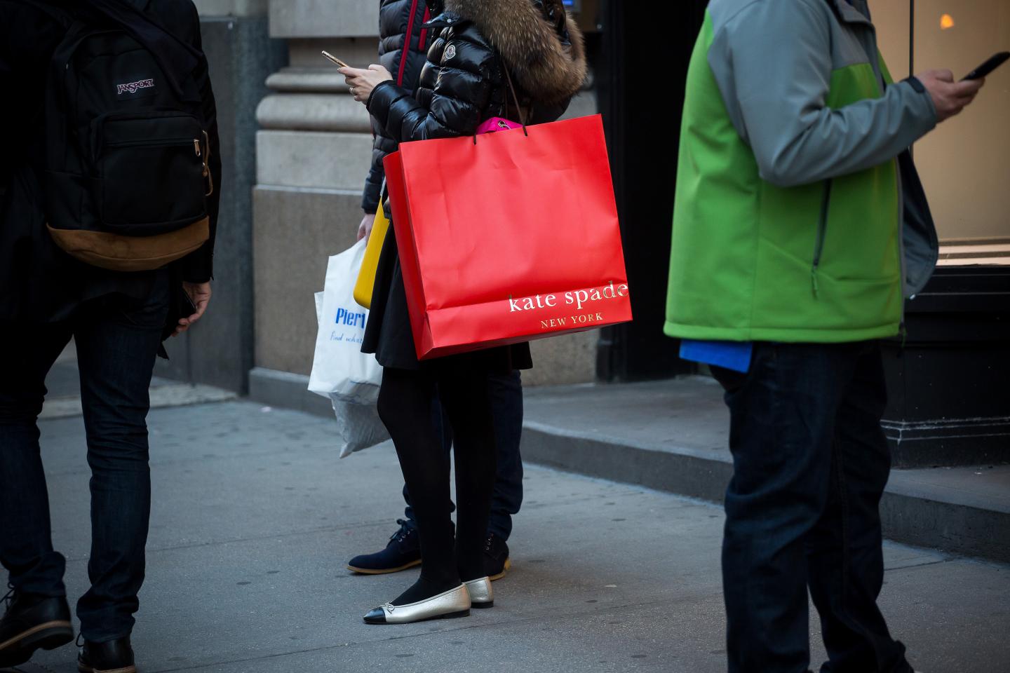 A shopper carries a Kate Spade &amp; Co. bag outside a store in New York, U.S., on Sunday, Feb. 28, 2016.