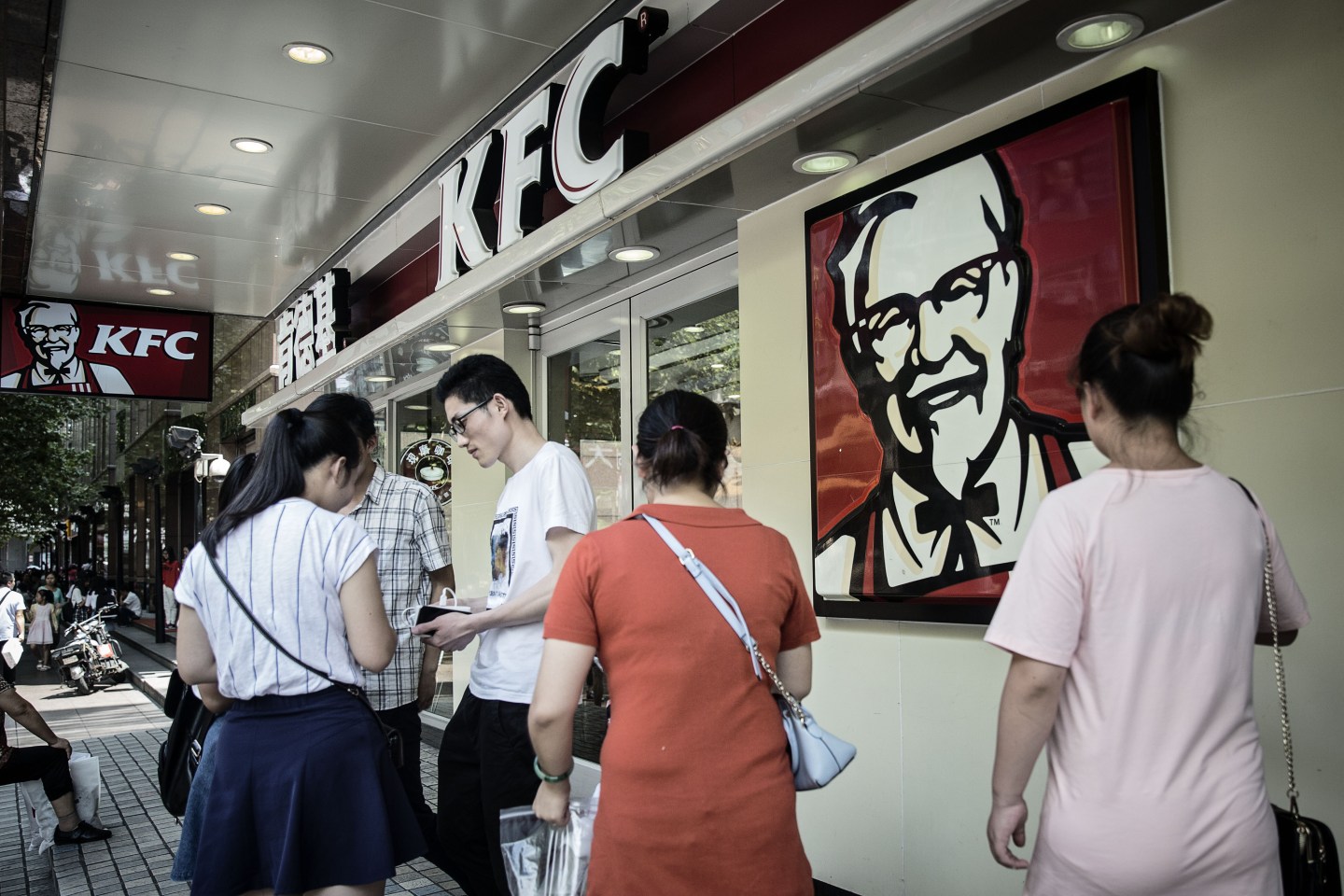 Pedestrians walk past a Yum! Brands Inc. KFC restaurant in Shanghai, China.