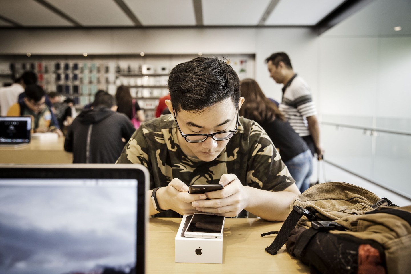 A customer looks at an Apple Inc. iPhone 7 Plus at the Apple Store inside the IAPM shopping mall in Shanghai, China, on Friday.