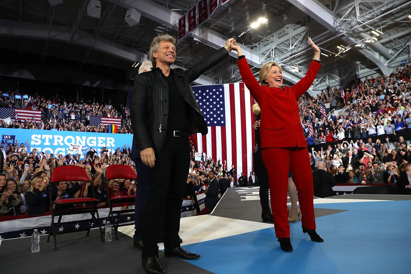 Democratic presidential nominee Hillary Clinton (R) with musician Jon Bon Jovi during a campaign rally on November 8, 2016.