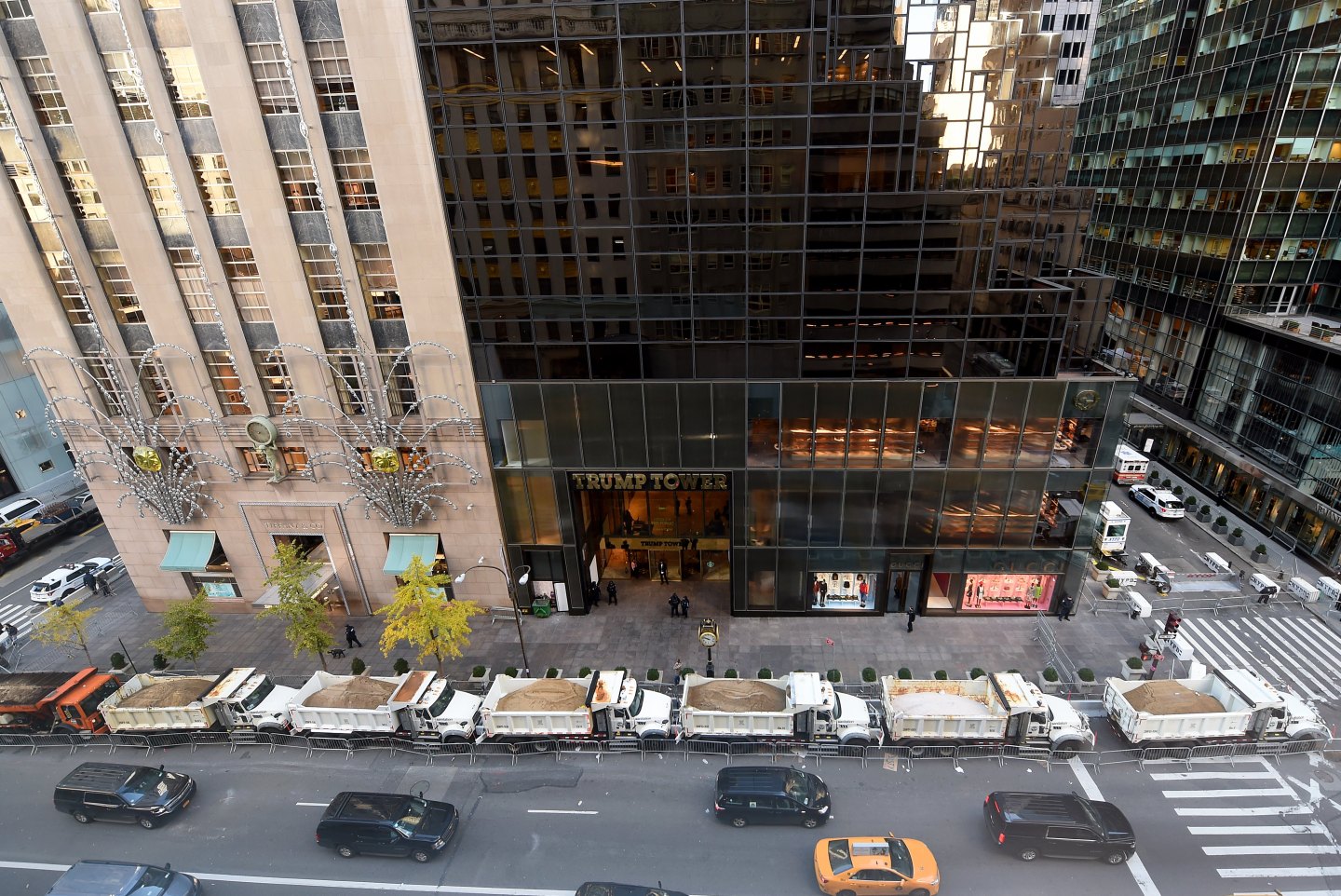 A protective barrier of Sanitation Department trucks are parked in front of Trump Tower on 5th Avenue in New York City.