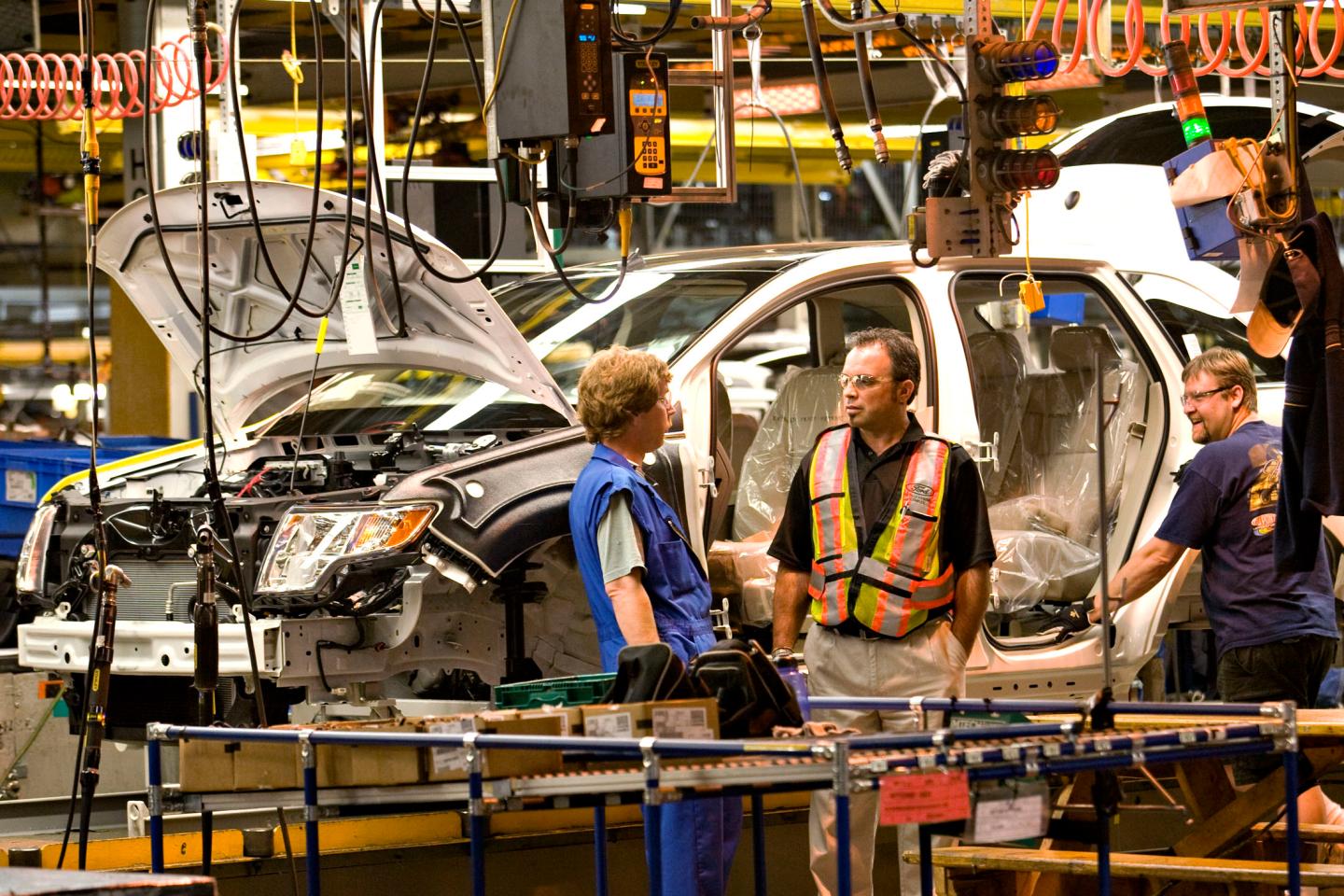 Workers take a break during an unexpected delay on the Ford