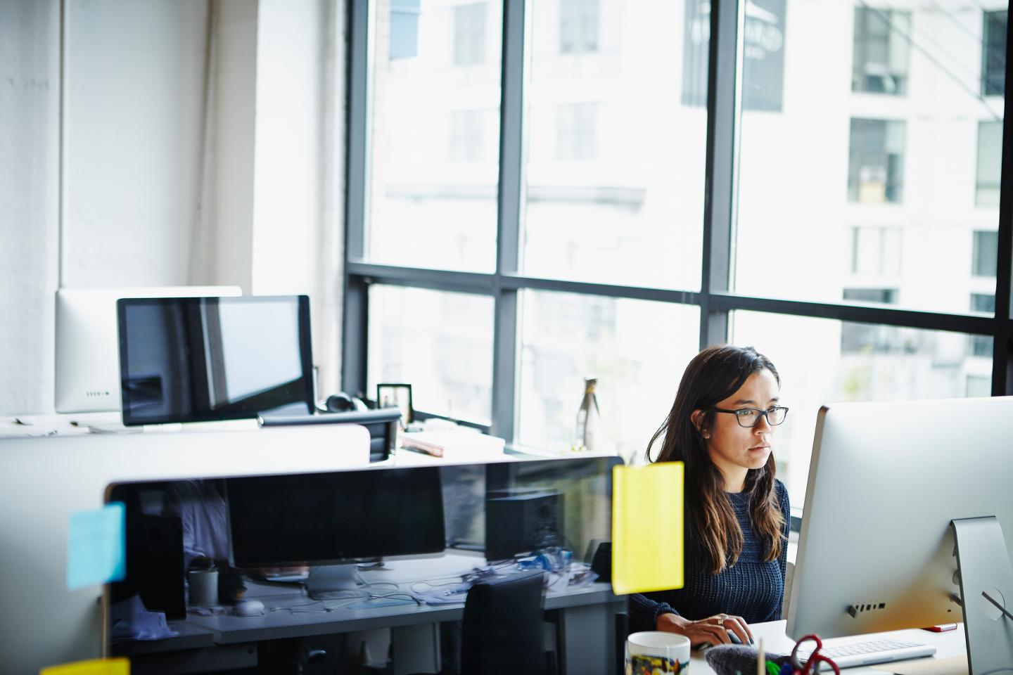 Businesswoman sitting at desk working on computer