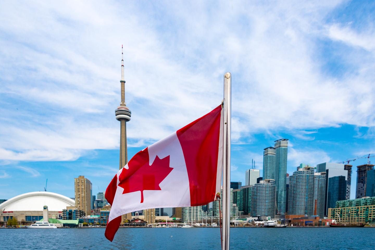 Canadian flag and the Toronto skyline. The flags waves from