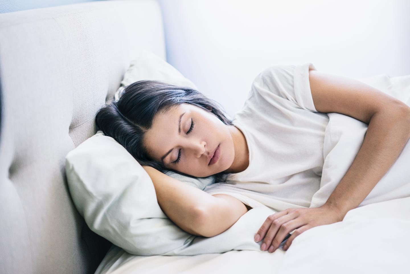 woman eyes closed laying in bed