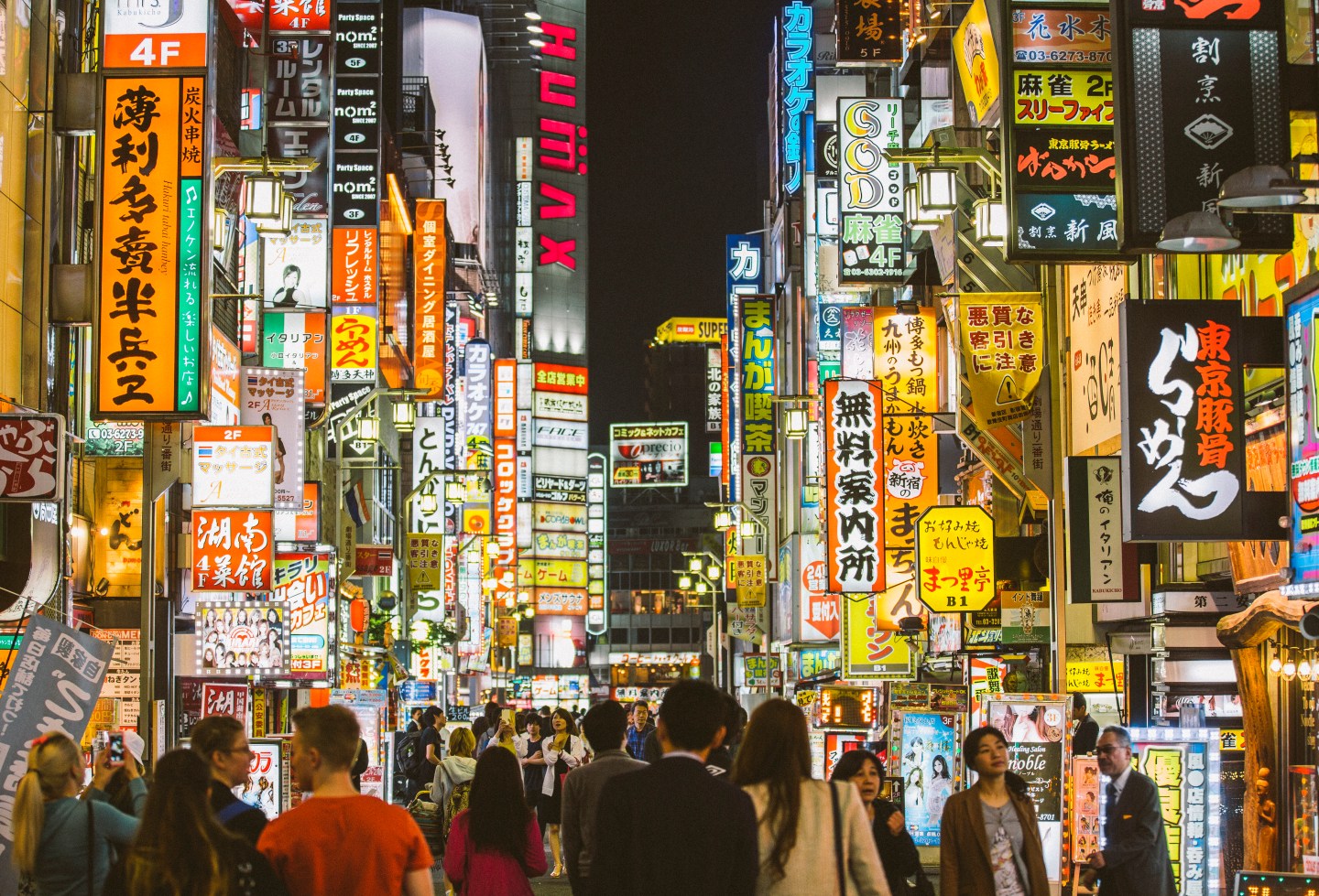 People walking among neon sign in Shinjuku, Tokyo