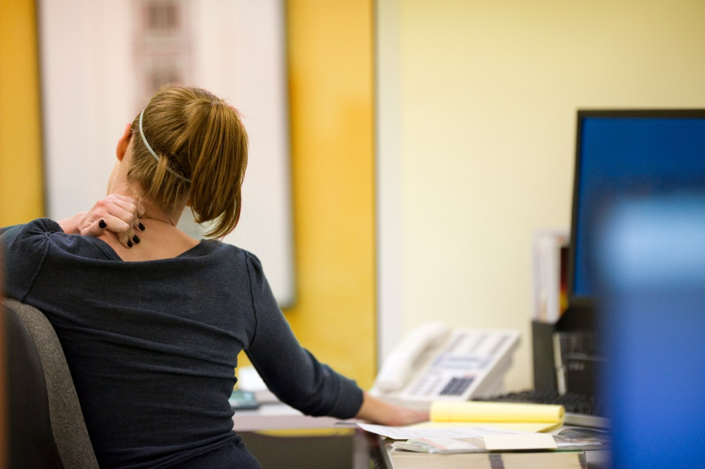 Stressed woman holds neck