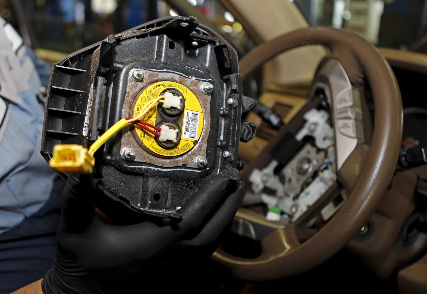 File photo of technician Edward Bonilla holding a recalled Takata airbag inflator in Miami