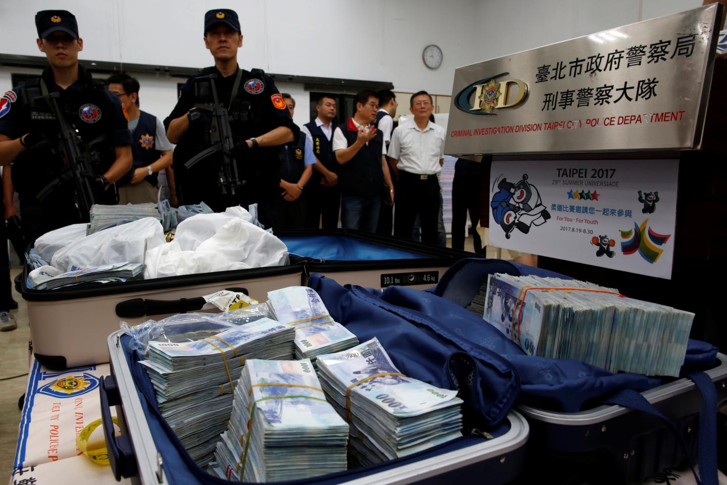Taiwanese banknotes are displayed after they were found from a hotel room rented by one of the suspects involved in stealing from automated teller machines (ATM) in Taipei