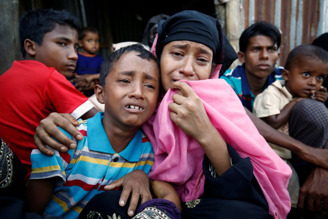 A Rohingya Muslim woman and her son cry after being caught by Border Guard Bangladesh while illegally crossing at a border check point in Coxs Bazar