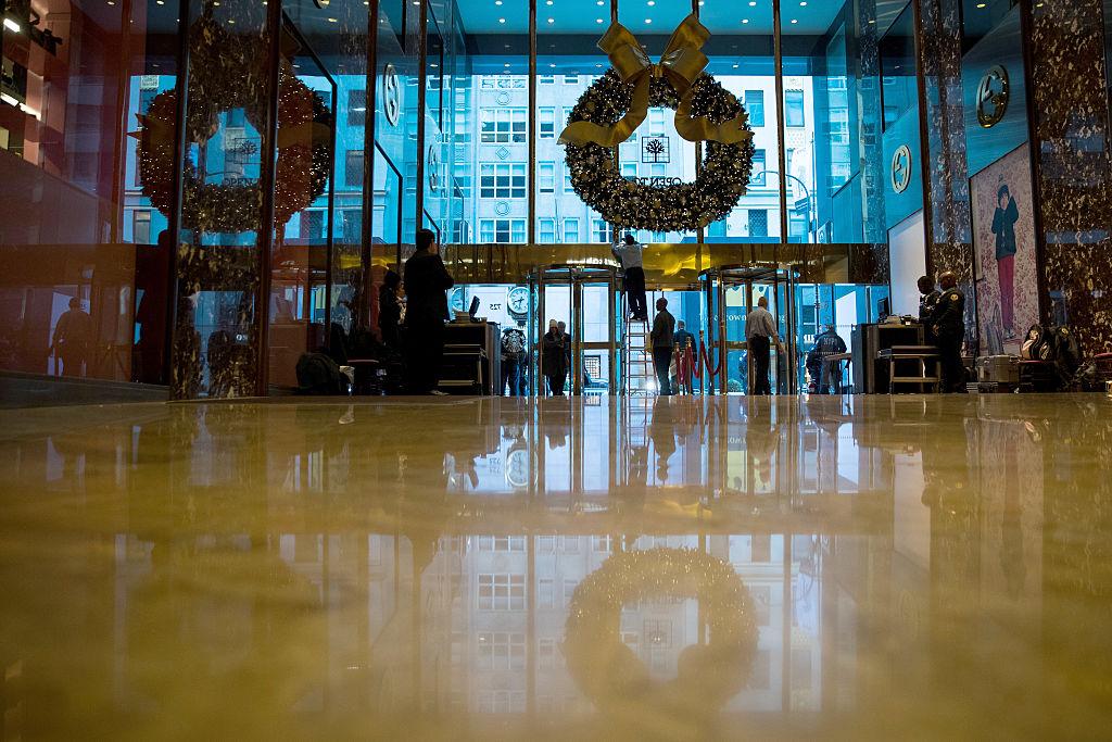 NEW YORK, NY - NOVEMBER 22: A maintenance worker makes adjustments on a wreath hanging at the entrance of Trump Tower, November 22, 2016 in New York City. President-elect Donald Trump and his transition team are in the process of filling cabinet and other high level positions for the new administration. (Photo by Drew Angerer/Getty Images)