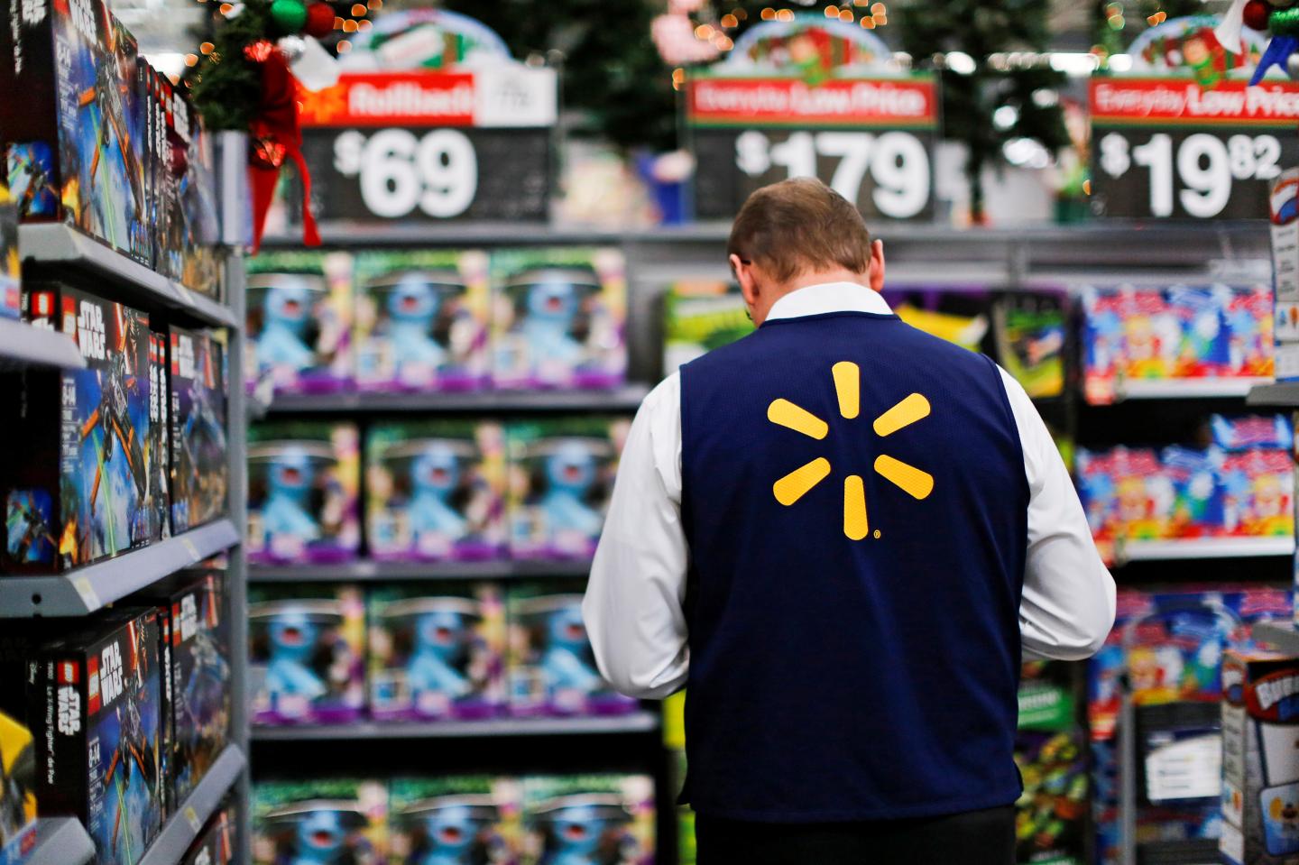 A Walmart worker organises products for Christmas season at a Walmart store in Teterboro