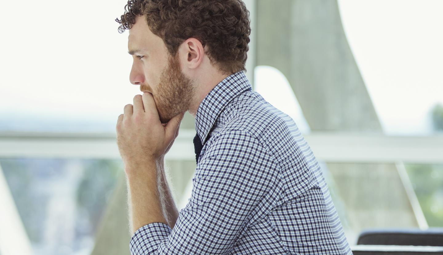 Pensive businessman sitting in office lobby