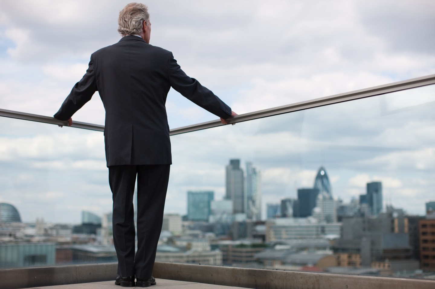 Businessman standing on urban balcony