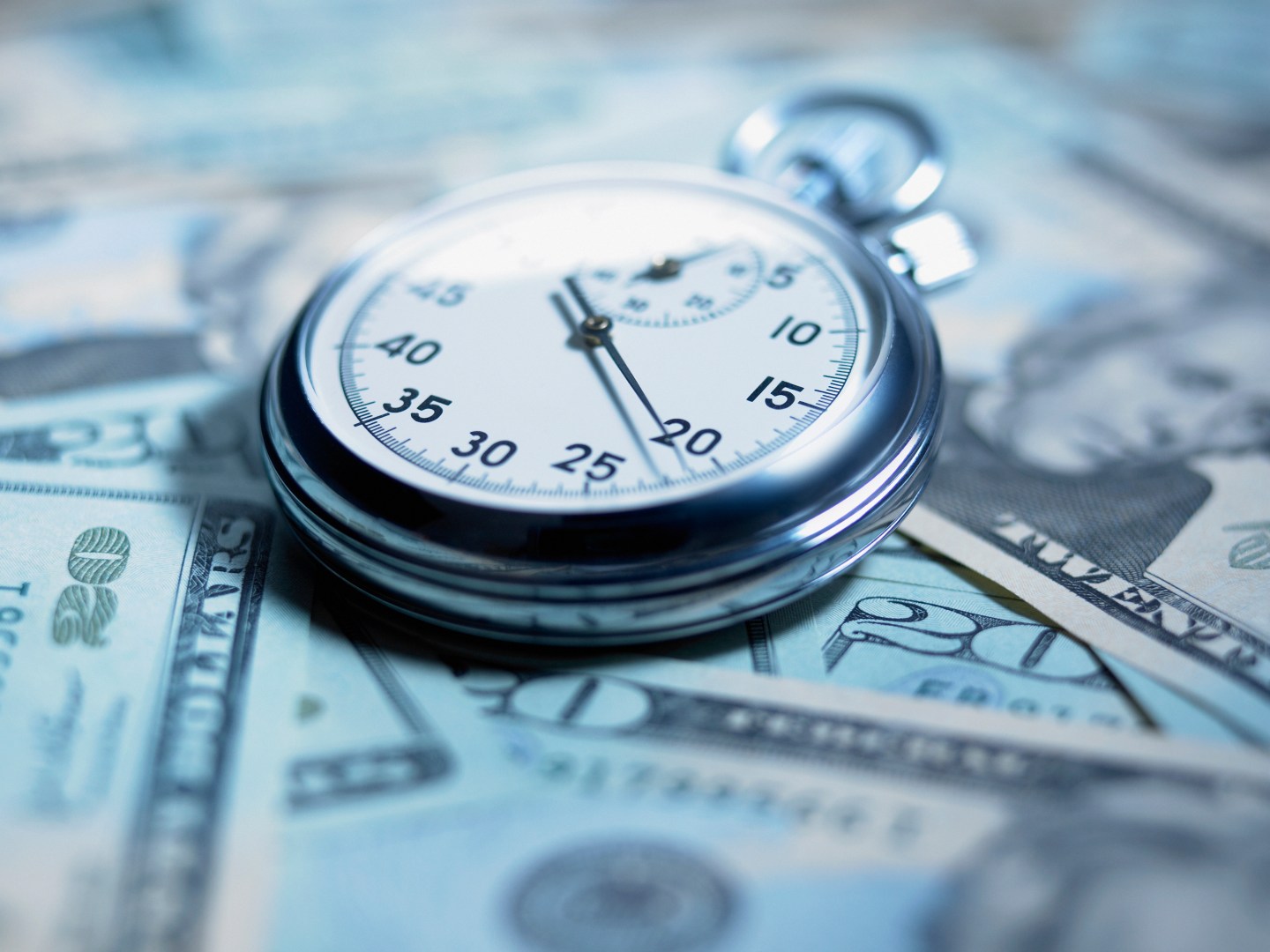 Close up of stopwatch on 20 dollar bills