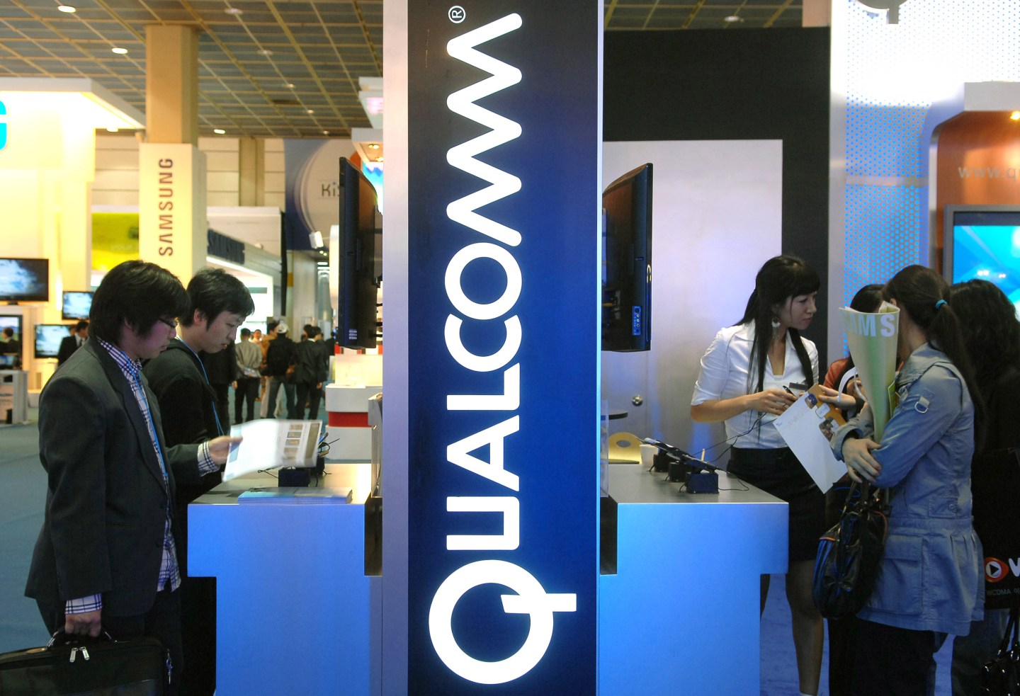 Visitors look around a Qualcomm display at the Korea IT Show