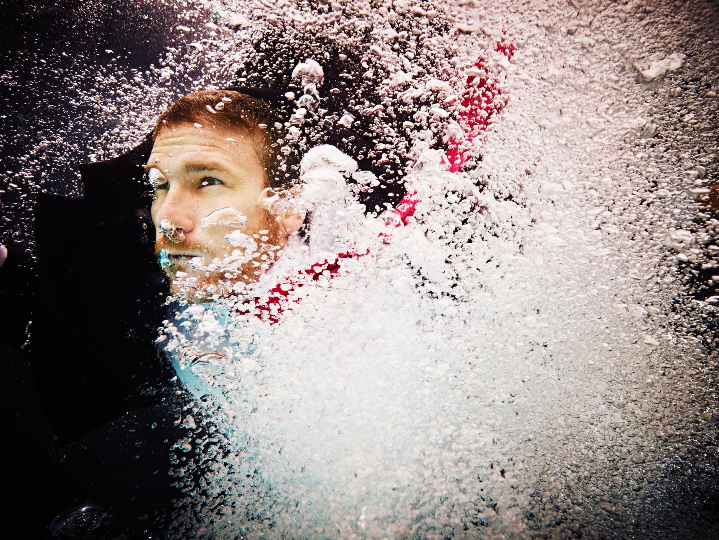 Underwater view of businessman in turbulent water