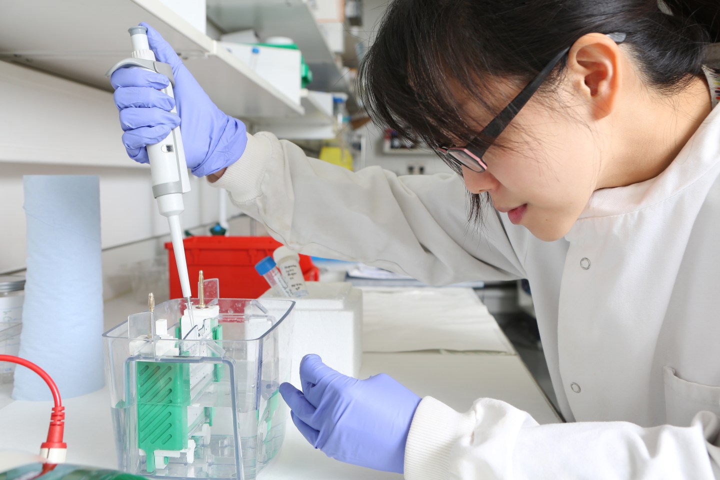 female scientist pipetting gel into machine