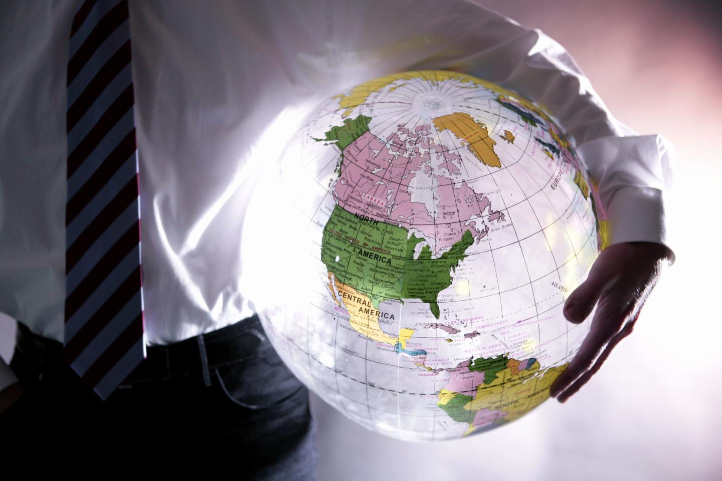 Globalization - manager with a globe under his arm.