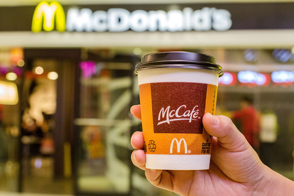 BEIJING, CHINA - 2015/01/28: A customer holds a cup of Coffee served by McCafe out of a McDonald's restaurant. In the 2014 fiscal figures released on January 23, 1% drop in global sales in 2014 highlighted the challenges McDonald’s faced. Especially, weak economy in Russia and supplier issue In China drives down McDonald's revenue growth in 2014. (Photo by Zhang Peng/LightRocket via Getty Images)