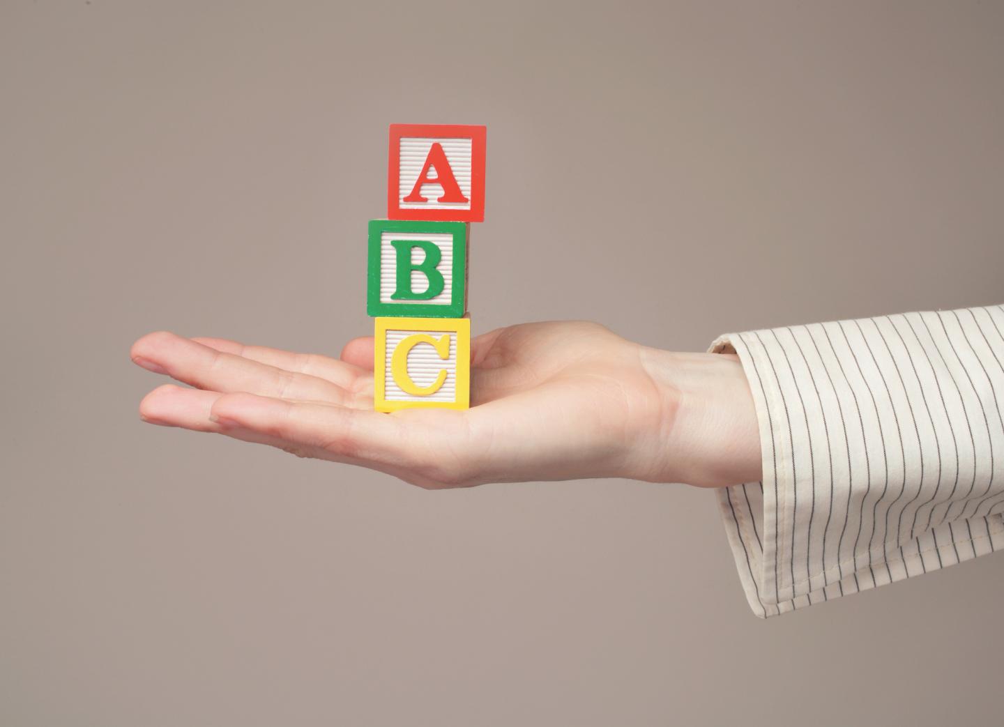 Woman holding out toy alphabet blocks, close-up