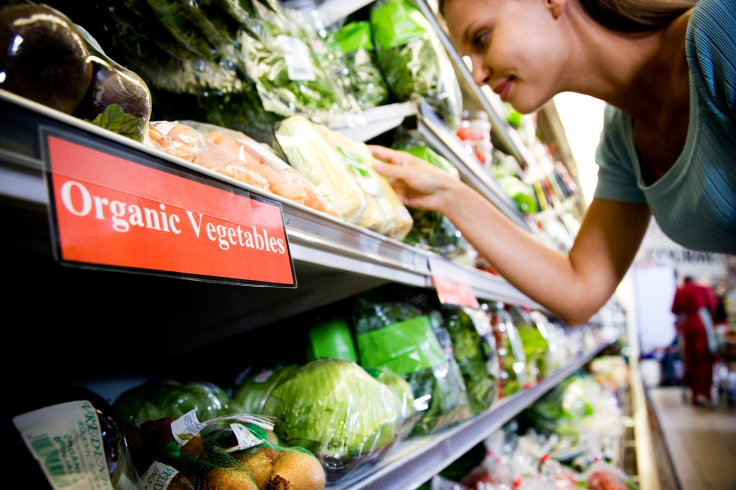Woman reading the label on an organic food packaging in a supermarket