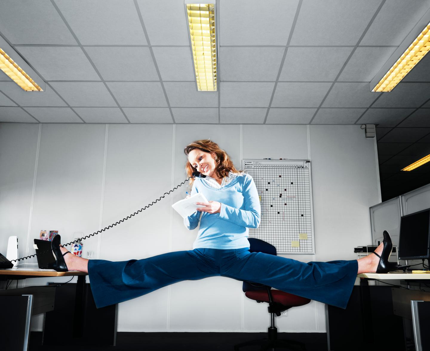 Woman talking on the phone doing the splits betwee