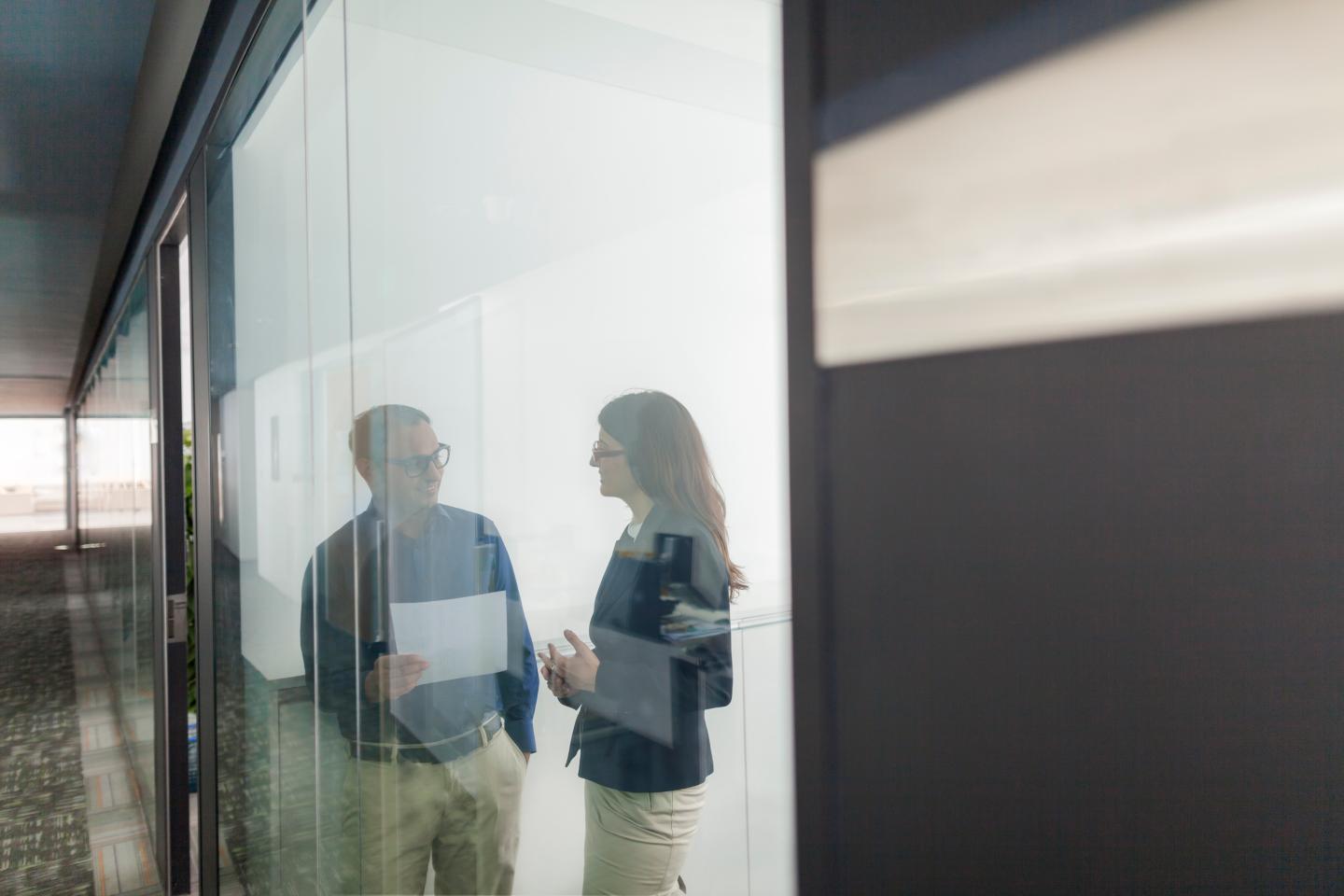 Pair of colleagues talking together in office