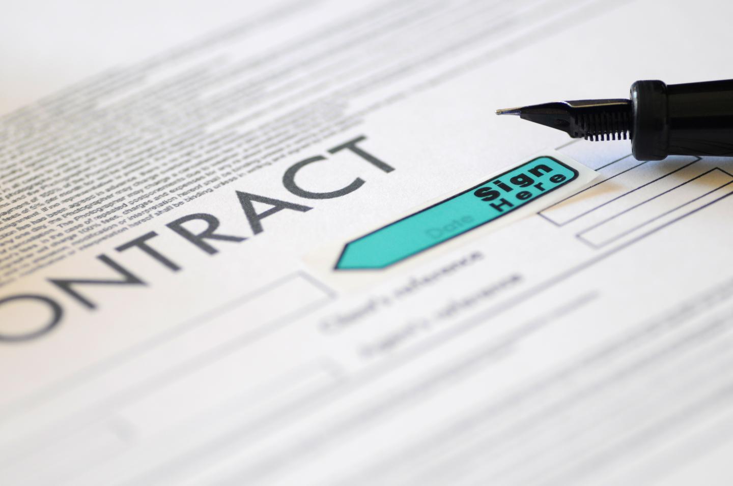 Focus of tip of fountain pen resting on a contract