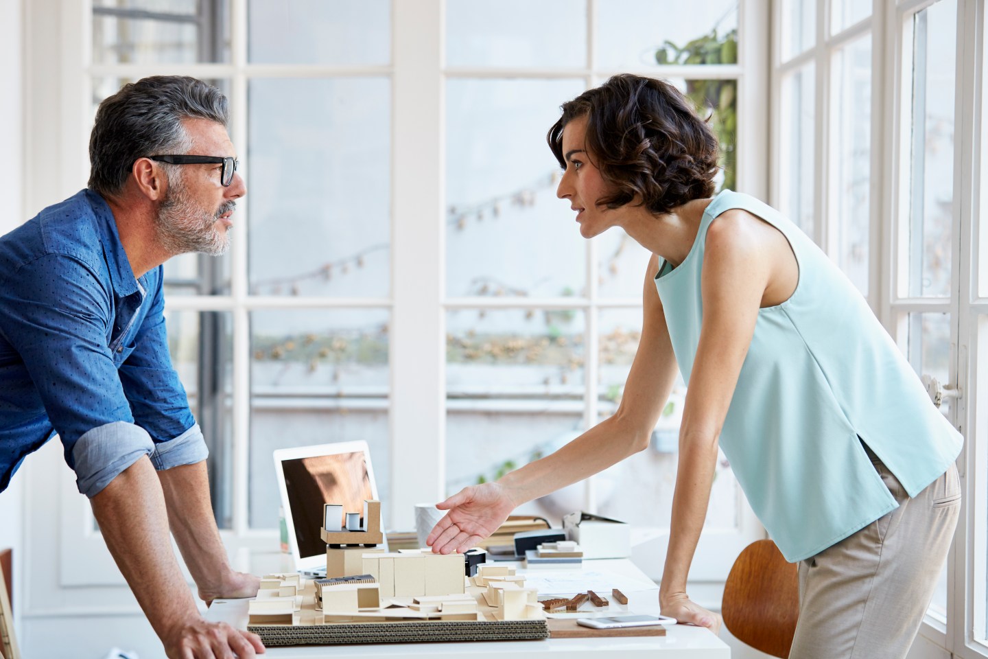 Architects discussing over building model