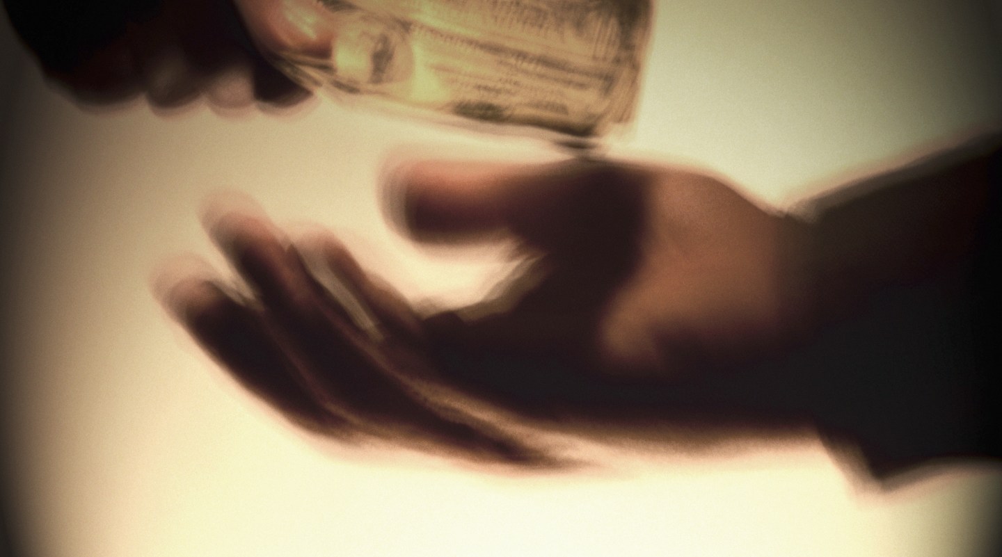 Two men exchanging money, close-up (digital enhancement)