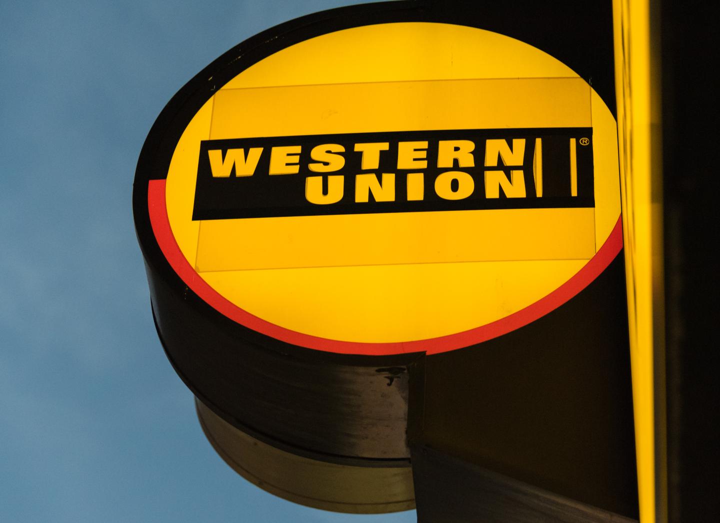 The glowing signage of Western Union at its agent location