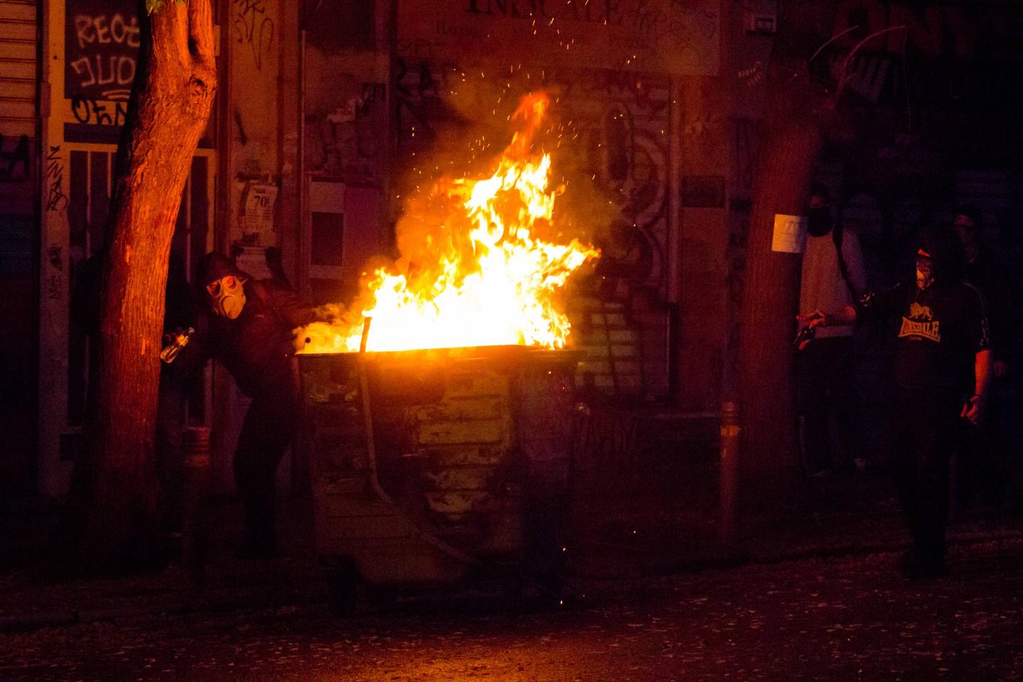 Rioters put a dumpster on fire to protect from tear gas