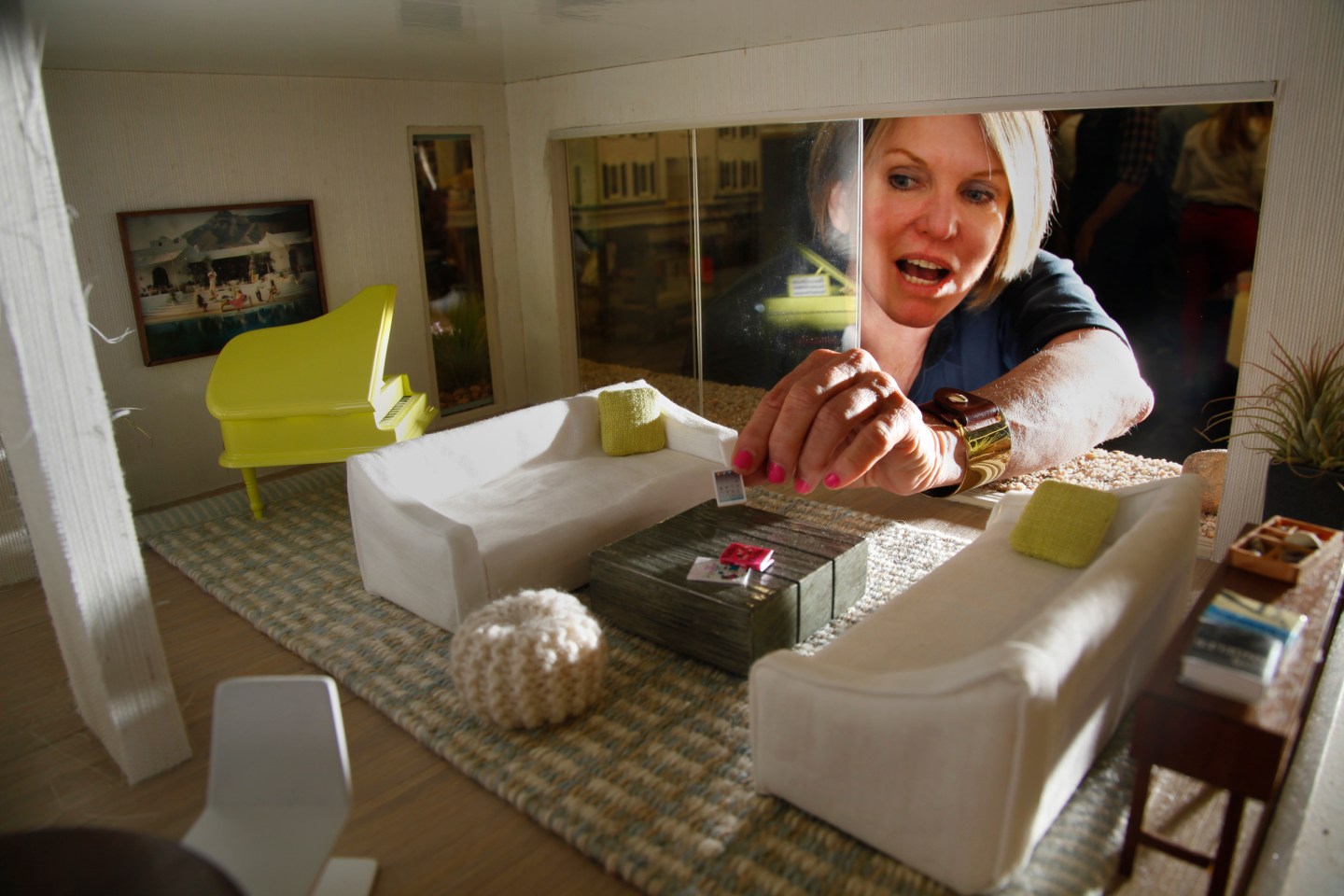 Interior designer Chris Barrett reaches through a sliding window wall in a contemporary beach dollh